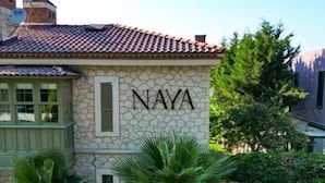 Un edificio de piedra con techo de tejas y el nombre 'NAYA' en la fachada.
