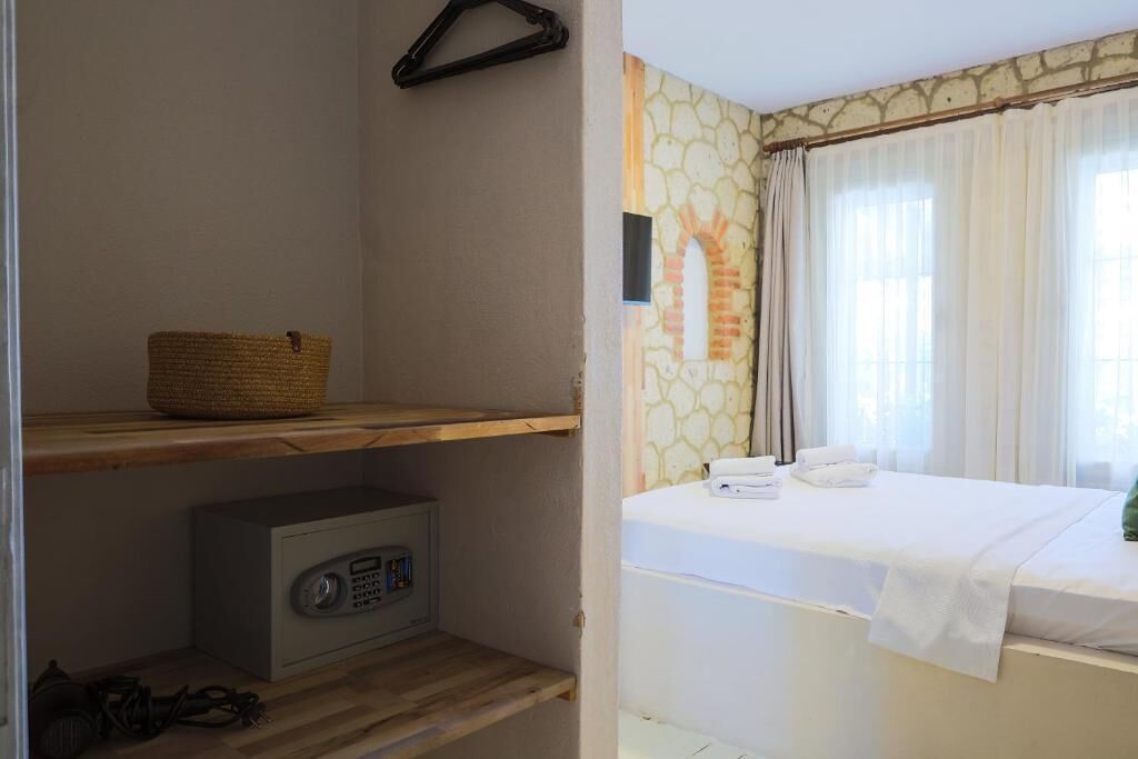 Een kamer met een bed, een radio, een mand en een muur met een stenen patroon.