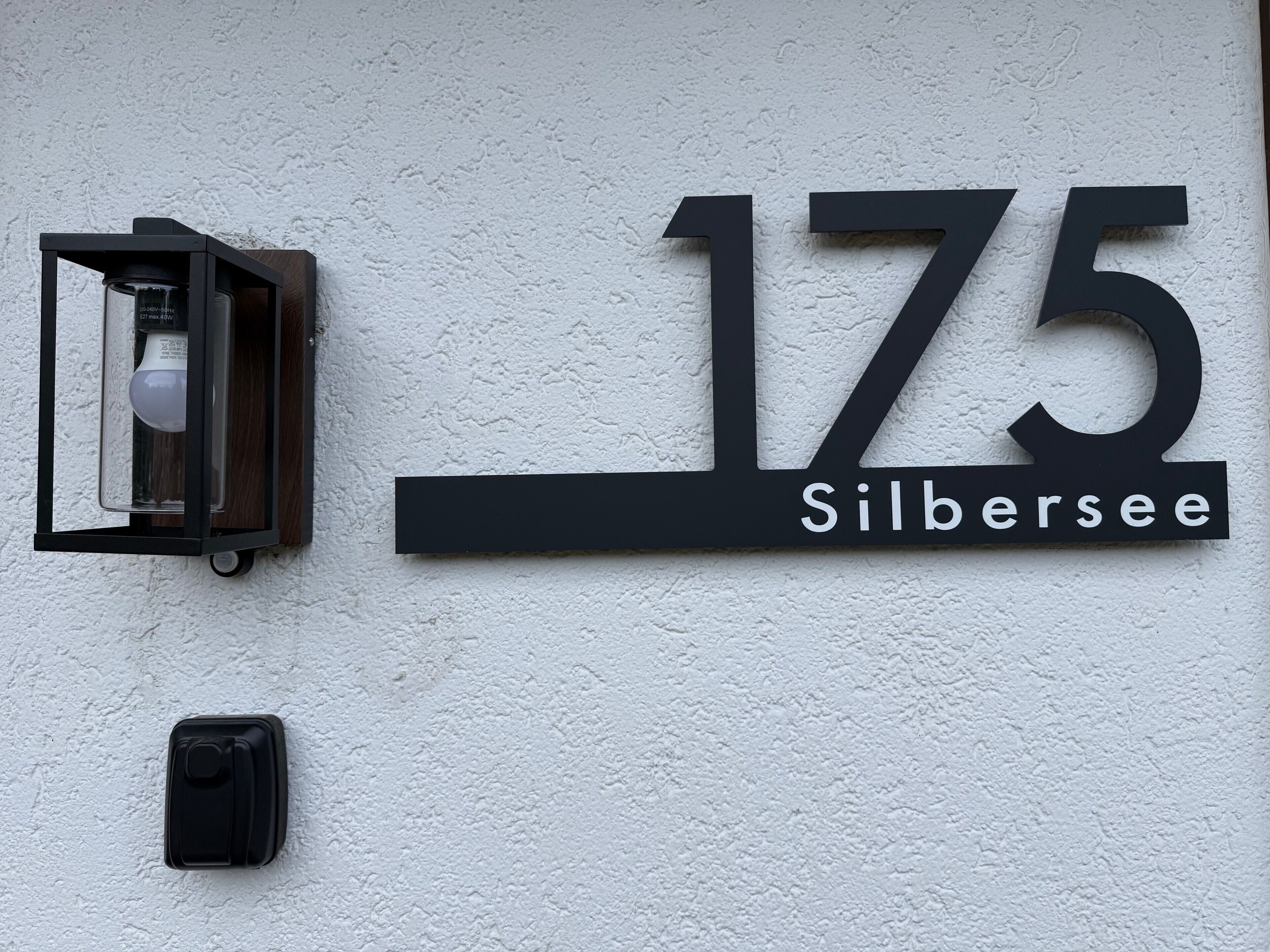 A wall-mounted sign with the number '175' and the name 'Silbersee' indicating a location or address.