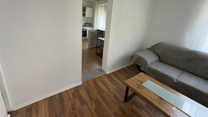 A living room with a sofa, a coffee table, and a kitchen in the background. - Apartment 'Liki' with Wi-Fi (Siegen)