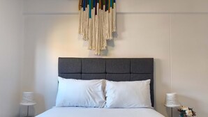 A bed with a grey upholstered headboard, white bedding, and two bedside tables with lamps and vases. - w Dreamy 2BR w Private Balcony in Cusco (Cusco)