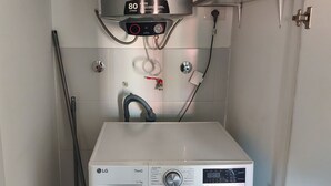 A compact laundry room with a washing machine, a steam iron, and a ventilation hood labeled 'sole' above the machine. - w Dreamy 2BR w Private Balcony in Cusco (Cusco)