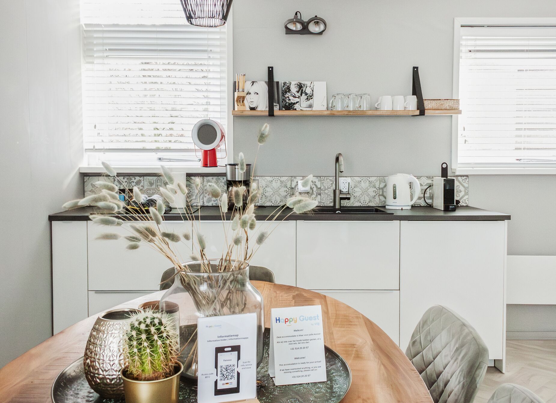 Een moderne keuken met een spoelbak, aanrecht en een eethoek met een tafel.