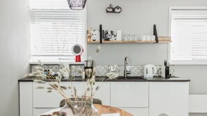 Een moderne keuken met een spoelbak, aanrecht en een eethoek met een tafel.