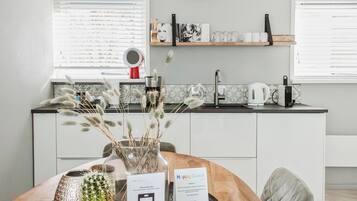 Een moderne keuken met een spoelbak, aanrecht en een eethoek met een tafel.