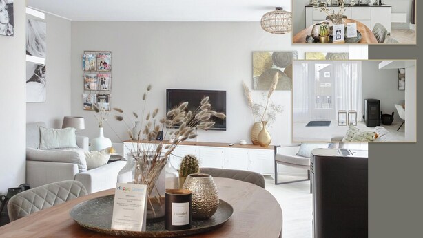 Een moderne woonkamer met een bank, een eettafel met placemat, een televisie en decoratieve elementen, waaronder een cactus en een vaas met gedroogde planten.