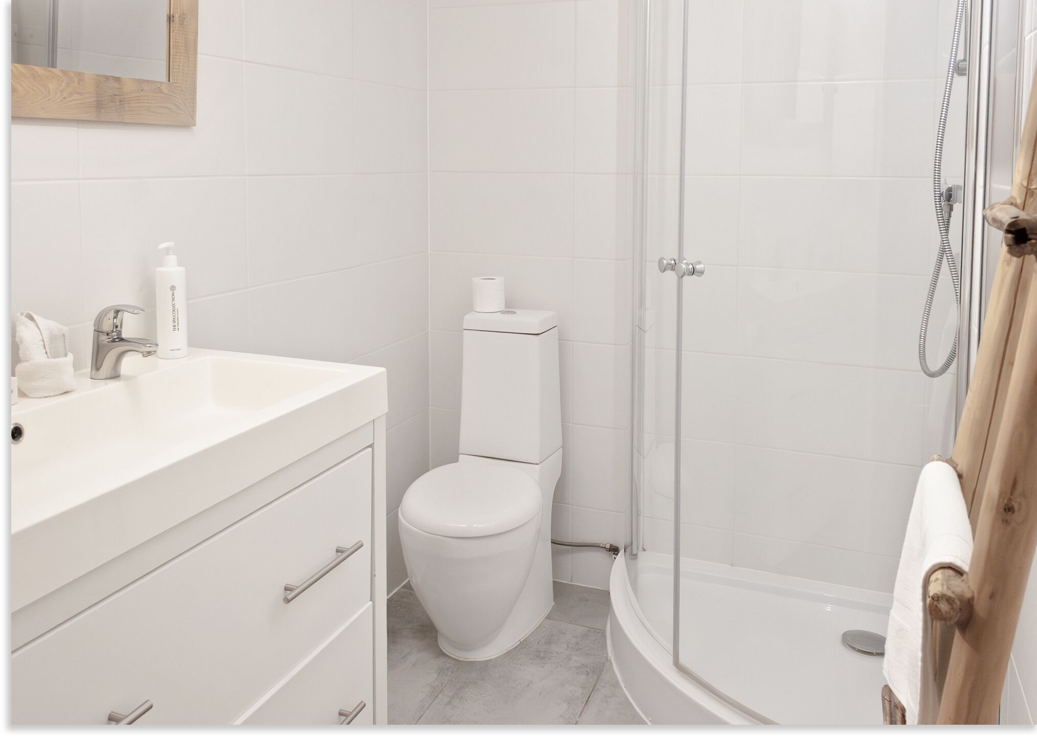 Een badkamer met een wit wastafel, toilet en douche.