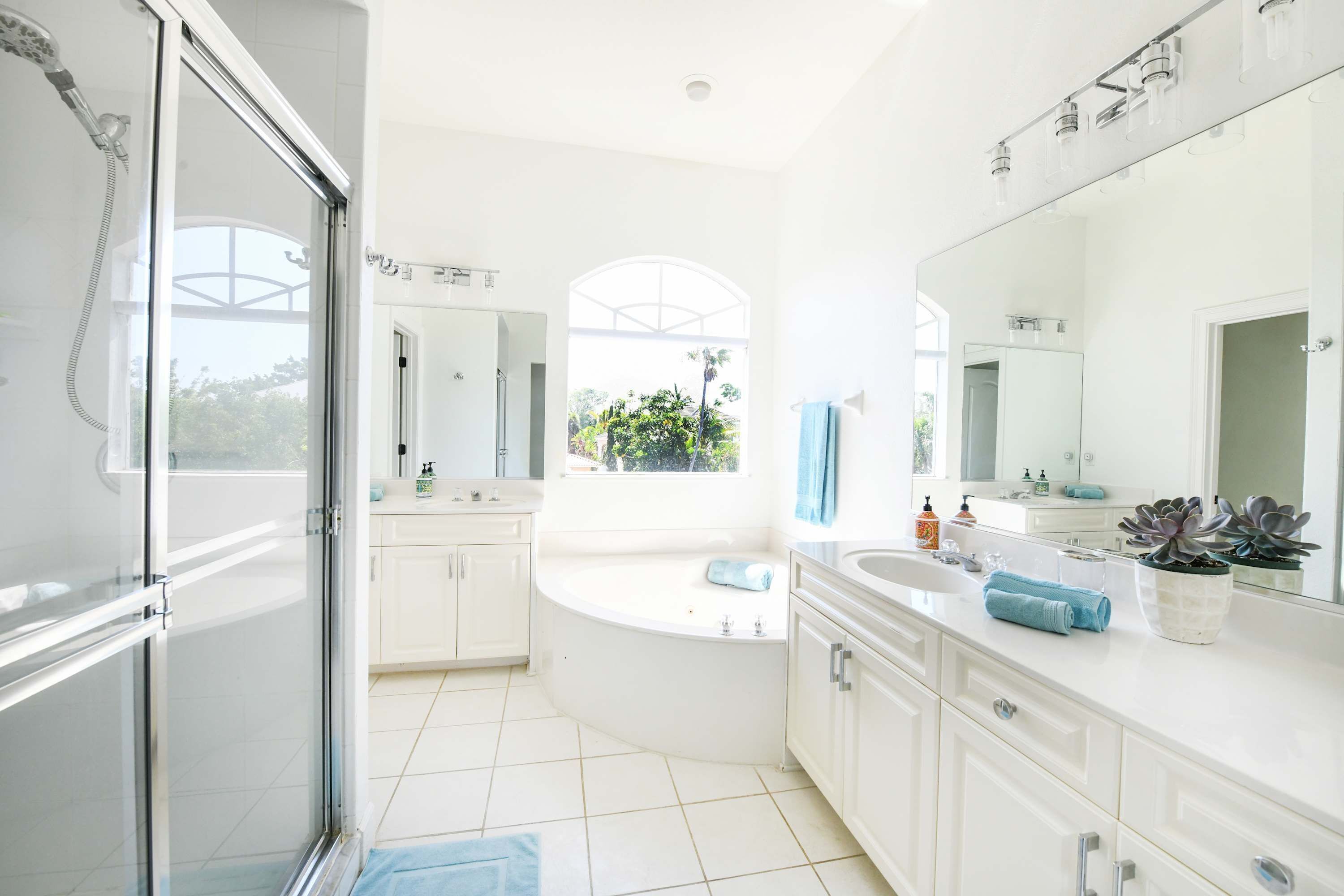 Une salle de bain moderne avec une douche à parois de verre, une baignoire sur pieds et un grand miroir.