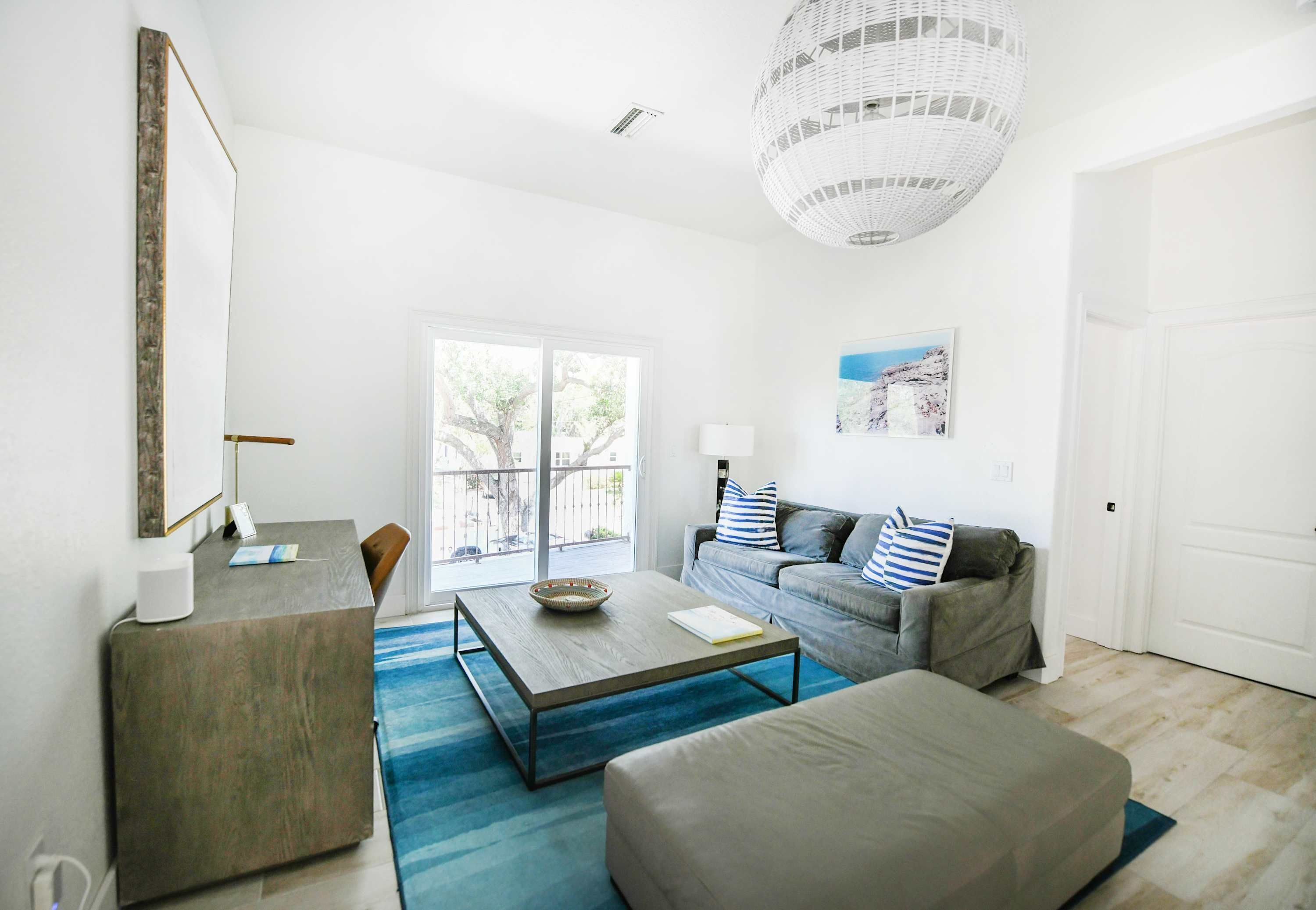 A modern living room with a sofa, coffee table, and a large window.
