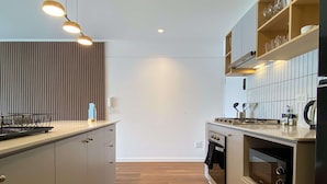 Eine moderne Küche mit Backofen, Mikrowelle und einer Holzausziehtheke.