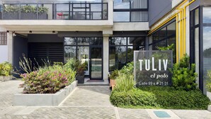 A modern building with a sign reading 'TULIV el polo' and an address. - w Unique Loft in Parque Virrey (Bogotá)
