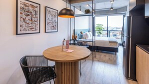 A modern office space with a round wooden table, black mesh chair, and two framed artworks on the wall. - w Unique Loft in Parque Virrey (Bogotá)