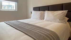 A hotel room with a bed, a window, and a view of buildings outside. - w Upscale 2BR w Balcony View in Miraflores (Lima)
