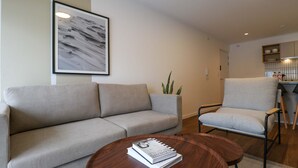 Ein Wohnzimmer mit einer Couch, einem Sessel und einem Couchtisch mit Büchern.