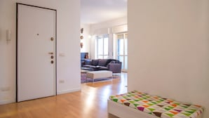 A room with a door, a bench, a sofa, and a window. - Bright Ambrose I Elegant 3 Bedroom Apartment With Balconies in Milan (Milan)
