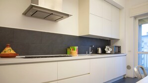A modern kitchen with a stove, sink, and cabinets. - Bright Ambrose I Elegant 3 Bedroom Apartment With Balconies in Milan (Milan)