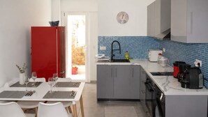 A compact kitchen with a red refrigerator, a sink, and a clock on the wall. - Athens Mets Loft - Cozy Urban Gem Park Views (Athens)