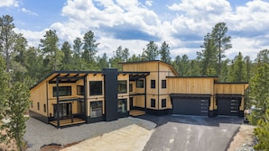 Ein modernes, zweistöckiges Haus mit Garage, umgeben von einem Wald.