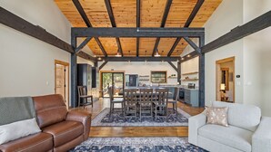 Ein geräumiger Wohnbereich mit Holzboden, einem Esstisch mit Stühlen, einem Sofa und einer Sitzecke.