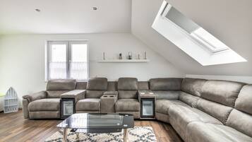 Ein modernes Wohnzimmer mit einer Eckcouch, einem Glastisch und einem Oberlicht.