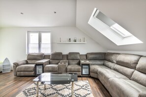 Una sala de estar moderna con un sofá modular, una mesa de centro de vidrio y un tragaluz.