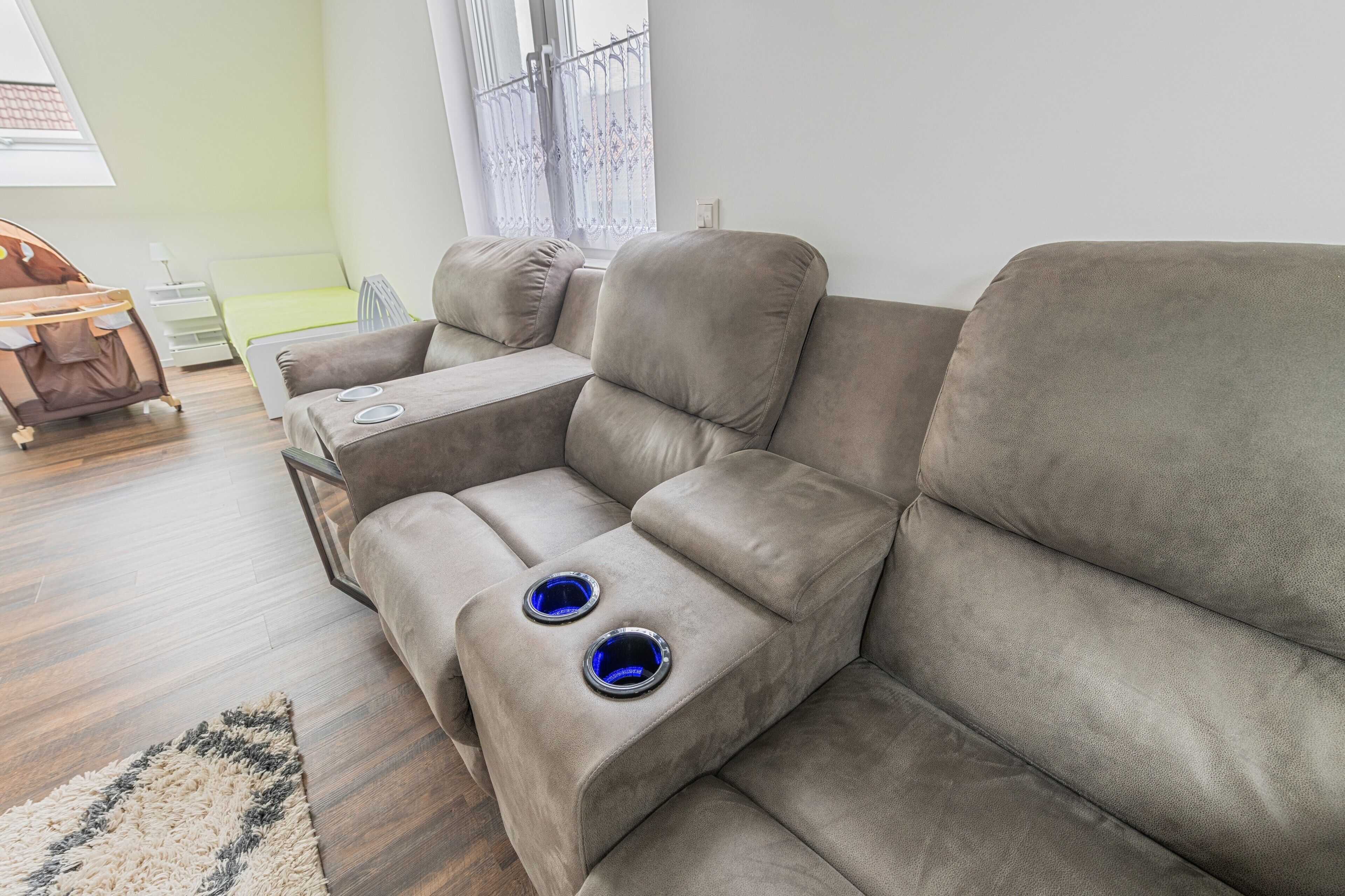 A sectional sofa with a built-in TV and cup holders.