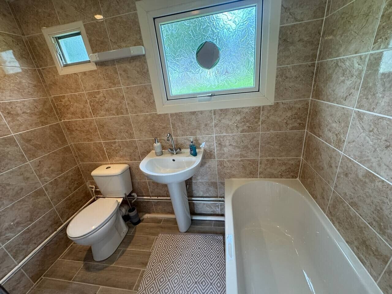 A bathroom with a toilet, sink, and bathtub.