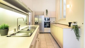 A modern kitchen with a stainless steel sink, a built-in oven, and a microwave. - 3 Bedroom Cosy Apartment (Antwerp)