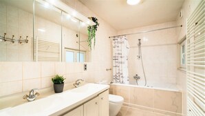A modern bathroom with a large mirror, a sink, a toilet, and a shower area. - 3 Bedroom Cosy Apartment (Antwerp)