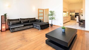 Una sala moderna con un sofá modular, una mesa de centro negra y una planta en maceta.