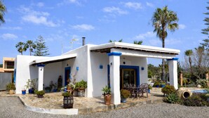 A white building with blue accents, a covered patio, and potted plants. - Can Romero - Whole house with private pool near Ibiza Town (Sant Josep de sa Talaia)