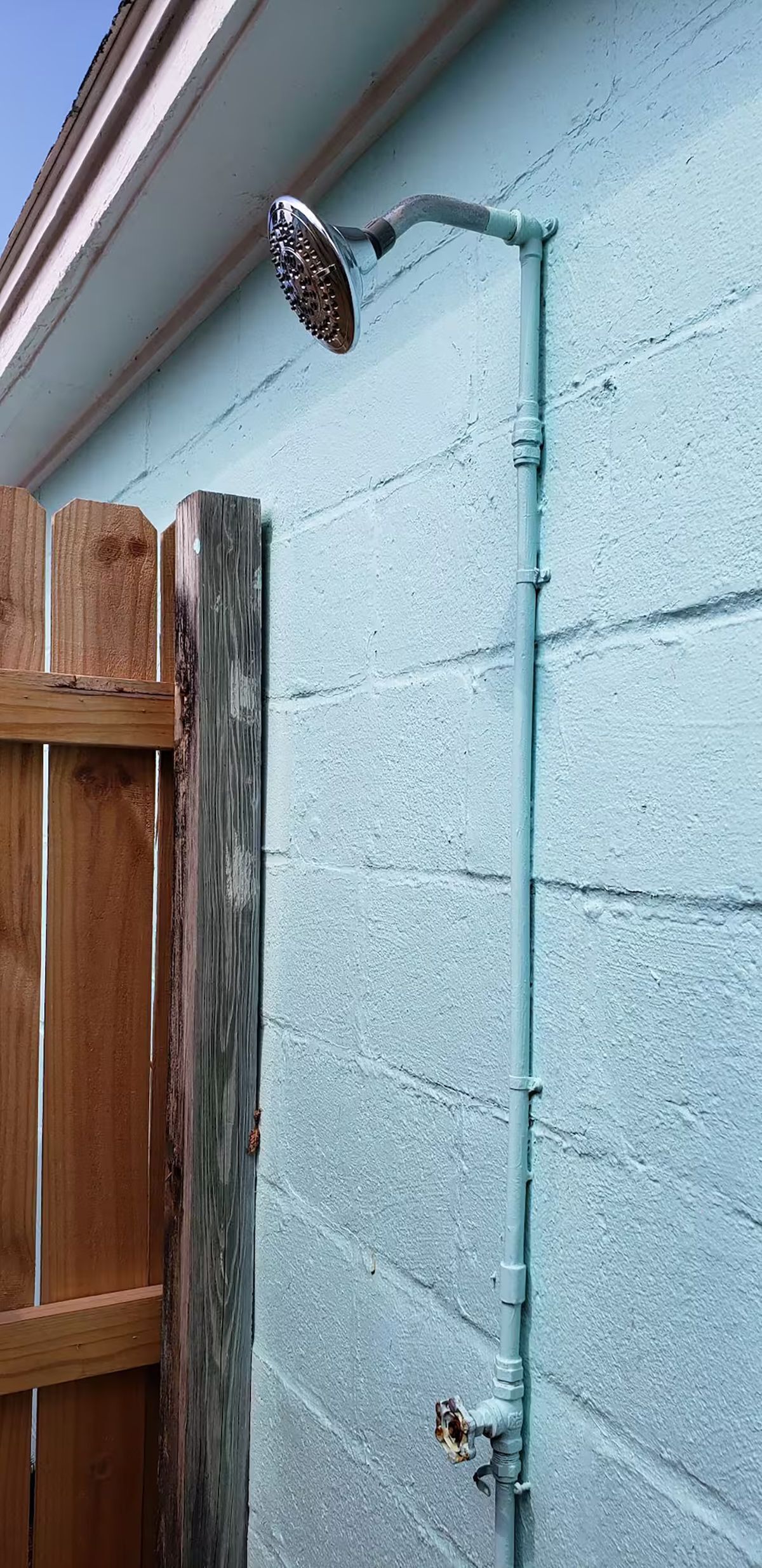 Un tubo metálico que sobresale de la pared exterior de un edificio, probablemente parte de una instalación de agua o desagüe.