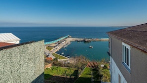 Vista costera con un puerto deportivo, muelle y un edificio de techo inclinado.