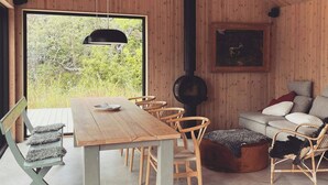 Un intérieur en bois comprenant une table à manger, des chaises, un canapé et une cheminée.