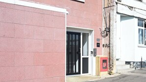 En bygning med en rød murstensfacade, en sort dør og en lille rød postkasse.