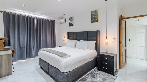 A modern bedroom with a large bed, bedside tables, a desk, and a wardrobe. - Boutique Hotel-Style Room In Ferndale-D4 (Randburg)
