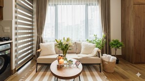 Ein Wohnzimmer mit einer Couch, einem Couchtisch mit Kerze und einer kleinen Pflanze.