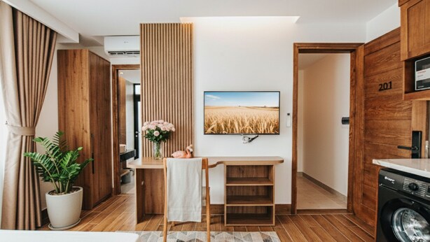Eine moderne Küche mit Holzausstattung, einer integrierten Waschmaschine und einem Essbereich mit Tisch und Stühlen.