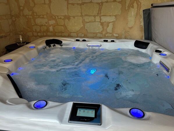 A hot tub with a digital control panel, multiple jets, and LED lighting.