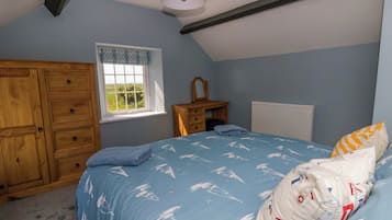 Une chambre à coucher avec un lit, une armoire en bois, une fenêtre et un radiateur.
