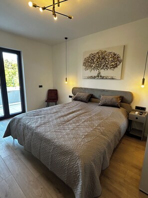 A bedroom with a large bed, a nightstand, a chair, a ceiling light fixture, and a window. - Villa Nati - Enjoyable 3-bedroom house with pool (Pula)