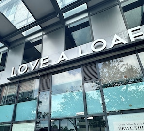 A building facade with large windows and the text 'LOVE A LOAF' prominently displayed. - Spacious Modern Suite for 7 Guests (George Town)