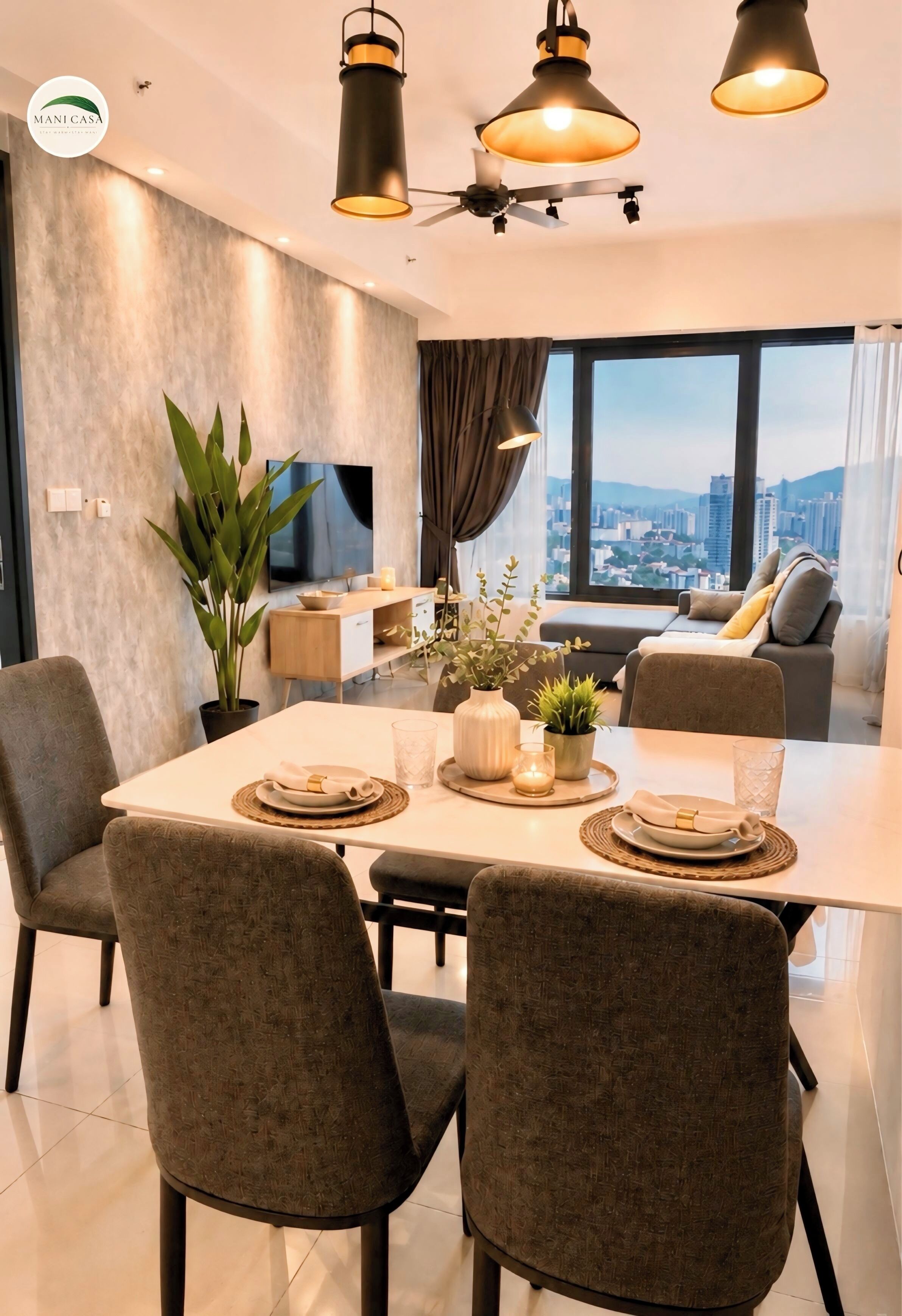 Un comedor moderno con una mesa dispuesta para cuatro personas, un ventilador de techo y vistas a la ciudad a través de amplios ventanales.