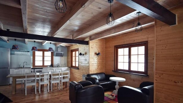 Un intérieur en bois comprenant une cuisine, un coin repas et un espace salon.