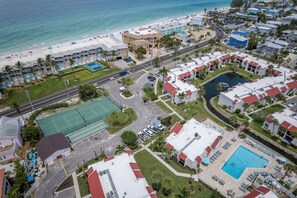 An aerial view of a coastal hotel with multiple buildings, a beach, and a swimming pool. - Secluded Beach Condo w/ Resort Access (Bradenton Beach)