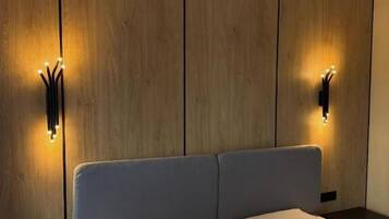 Ein modernes Hotelzimmer mit einem großen Bett, Holzwandverkleidung und Wandleuchten.