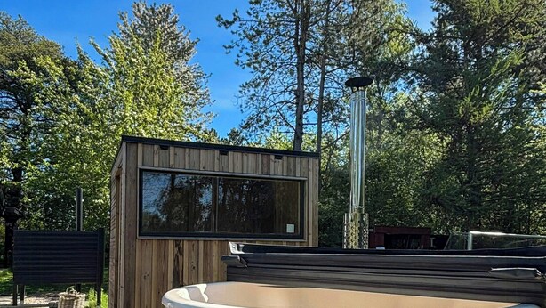 A wooden hot tub with a wooden deck and a small wooden structure with a window. - Summer house with wilderness bath by Kårup Forest (Fårevejle)