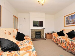 A living room with two sofas, a fireplace, a television, and a framed picture on the wall. - Porthmeor (Wadebridge)