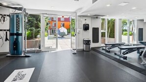 A gym with exercise equipment, a trash can, and a door leading outside. - Cozy condo with excellent views, 5 mins to arena (Vancouver)