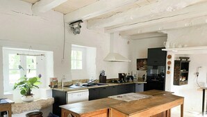 Une cuisine avec un îlot central en bois, un évier et une cuisinière.
